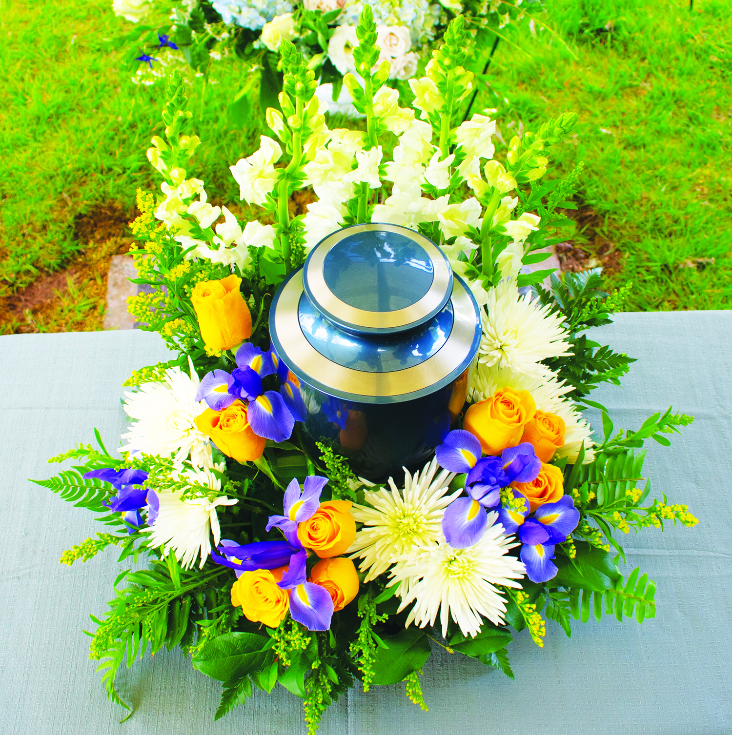 Cremation urn at funeral ceremony with floral arrangement