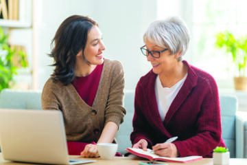 Adult daughter talking with elderly mother about planning and care decisions at home