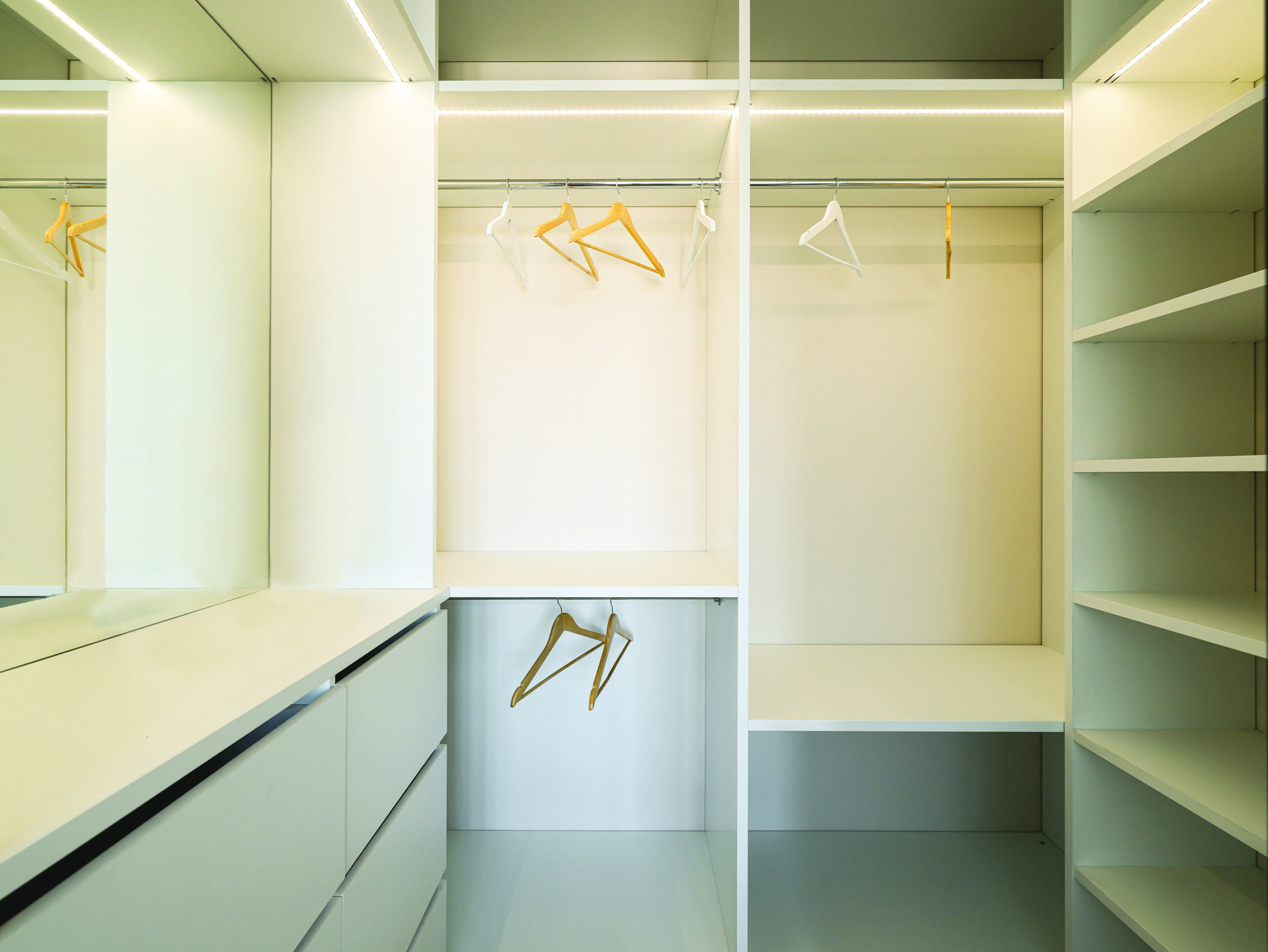 Empty walk-in closet with shelves and hangers representing space, reflection, and letting go
